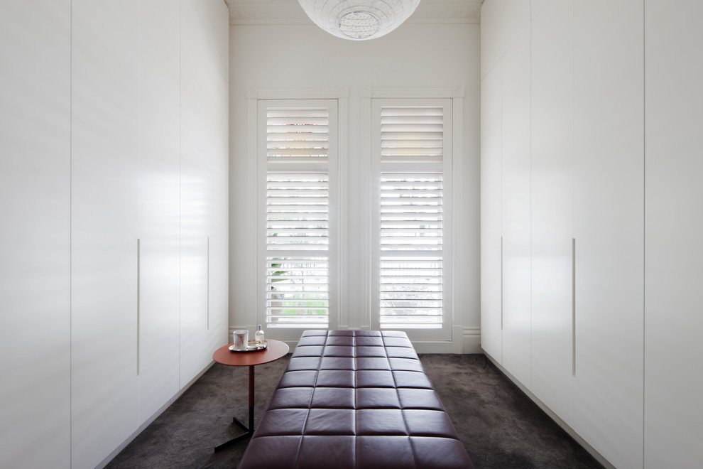 Neutraler Moderner Begehbarer Kleiderschrank mit flächenbündigen Schrankfronten, weißen Schränken, Teppichboden und braunem Boden in Melbourne
