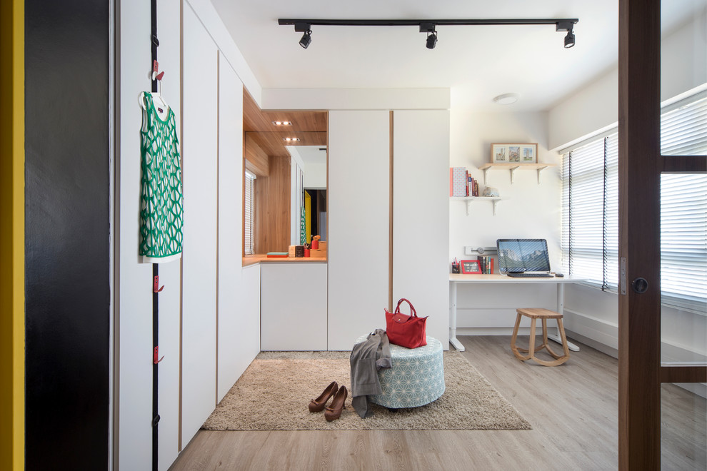 Moderner Begehbarer Kleiderschrank mit flächenbündigen Schrankfronten, weißen Schränken, braunem Holzboden und grauem Boden in Singapur