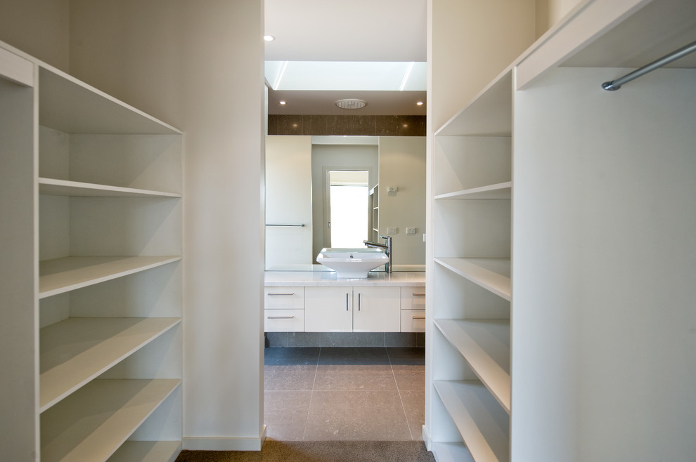 Minimalist carpeted walk-in closet photo in Melbourne with open cabinets and white cabinets