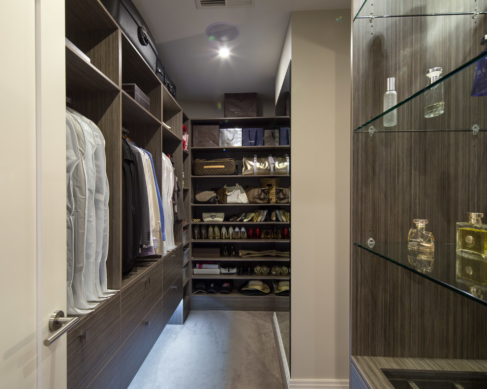 Design ideas for a contemporary gender neutral walk-in wardrobe in Adelaide with flat-panel cabinets, dark wood cabinets, concrete flooring and grey floors.