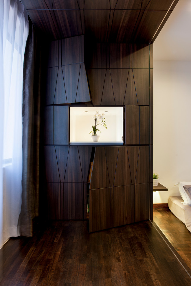 Immagine di un armadio o armadio a muro unisex minimal con parquet scuro, ante lisce, ante in legno bruno e pavimento marrone