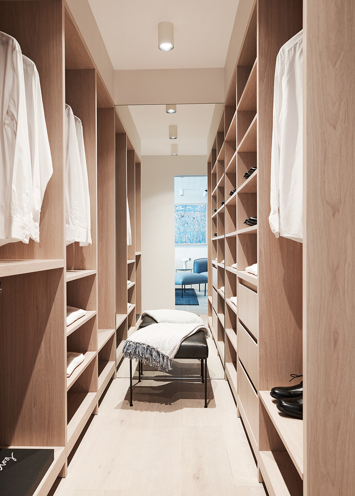 Пример оригинального дизайна: гардеробная комната унисекс в современном стиле с открытыми фасадами, светлыми деревянными фасадами, светлым паркетным полом и бежевым полом