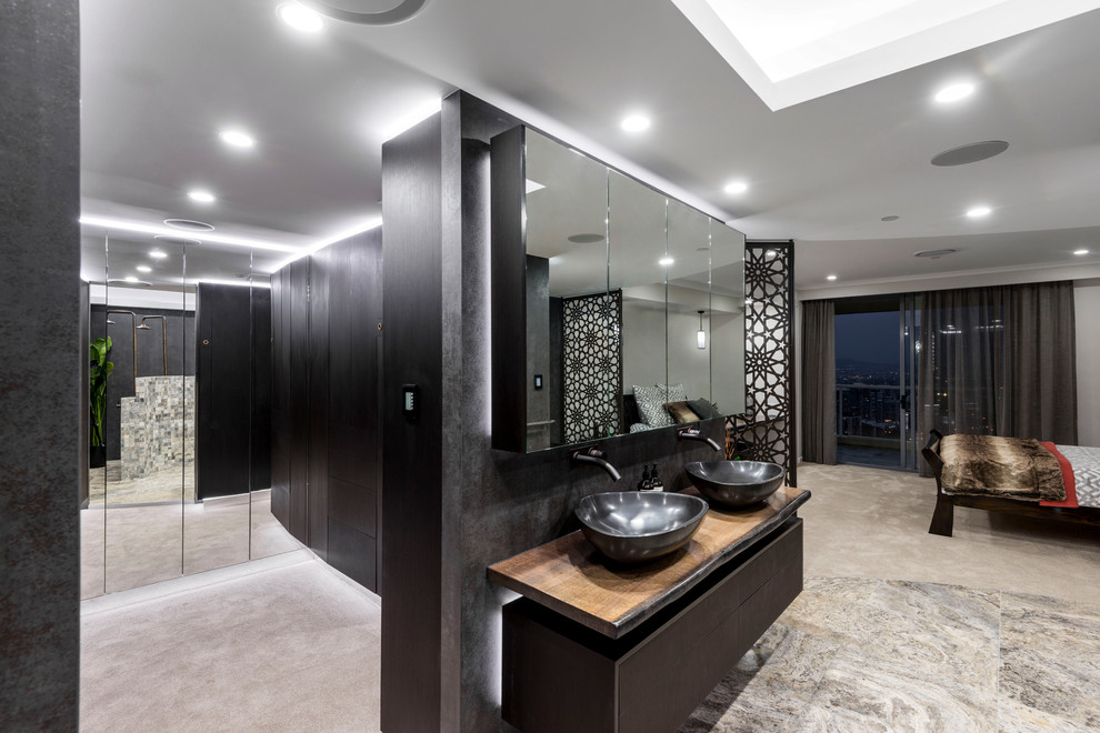 Example of a large trendy gender-neutral carpeted and beige floor walk-in closet design in Brisbane with flat-panel cabinets and dark wood cabinets