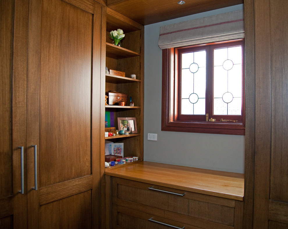 Idée de décoration pour un petit dressing victorien en bois brun neutre avec un placard à porte shaker et moquette.