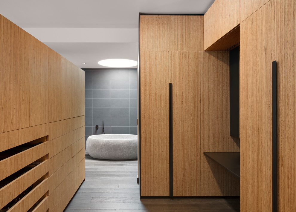 Diseño de vestidor unisex contemporáneo extra grande con armarios con paneles lisos, puertas de armario de madera oscura, suelo de madera oscura y suelo marrón