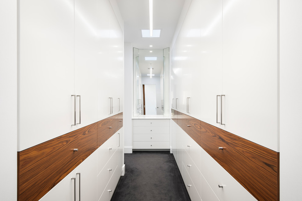 Photo of a large contemporary gender neutral walk-in wardrobe in Adelaide with flat-panel cabinets, white cabinets, carpet and grey floors.