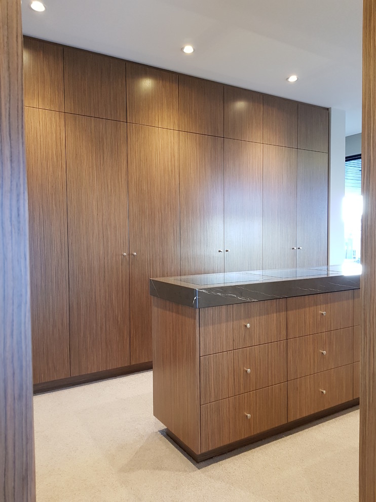 Cette photo montre un grand dressing room tendance en bois brun neutre avec moquette et un sol beige.