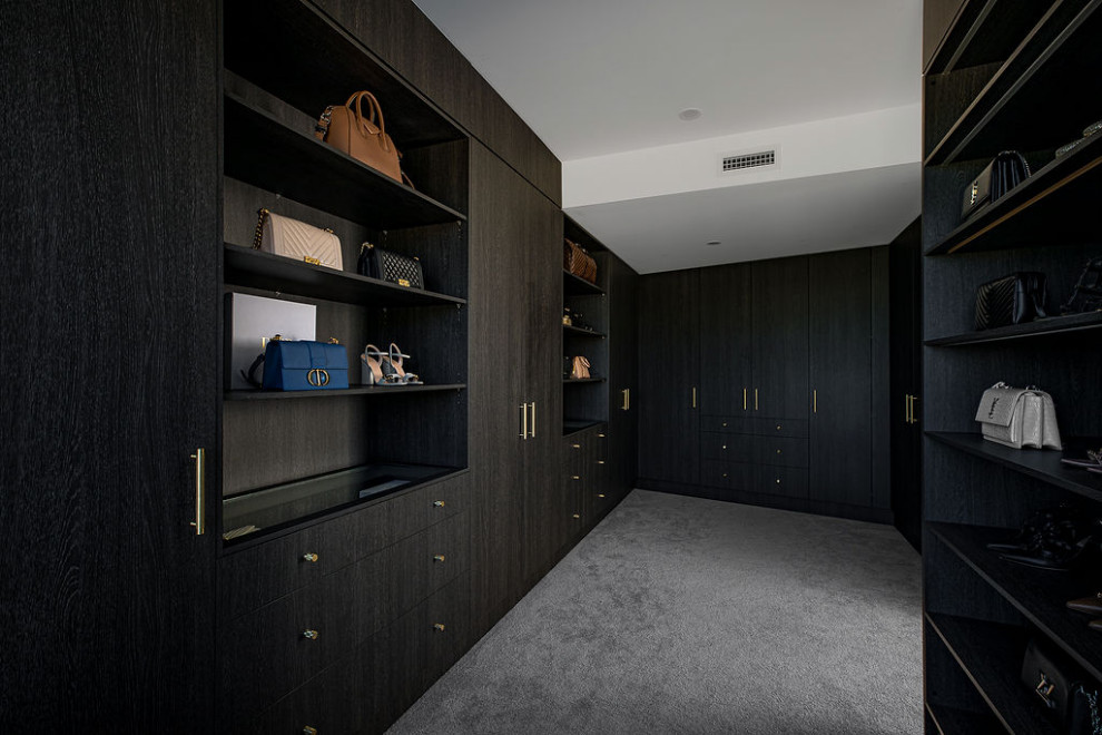 Großes Modernes Ankleidezimmer mit Einbauschrank, offenen Schränken, dunklen Holzschränken, Teppichboden und grauem Boden in Sydney
