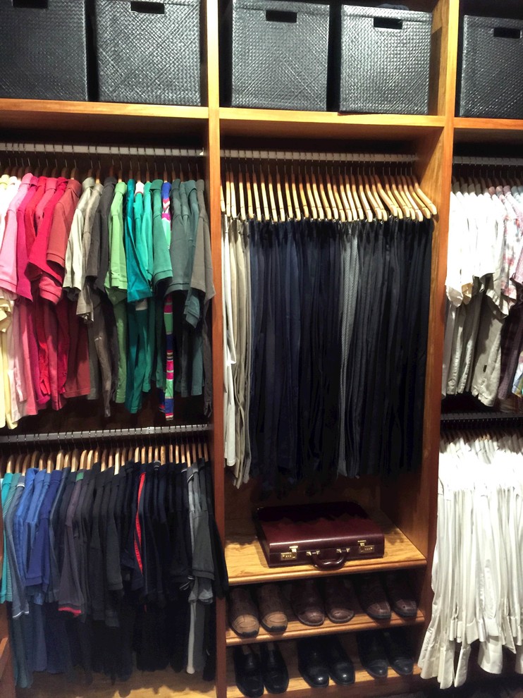 This is an example of a large classic walk-in wardrobe for men in Sydney with open cabinets, medium wood cabinets and light hardwood flooring.