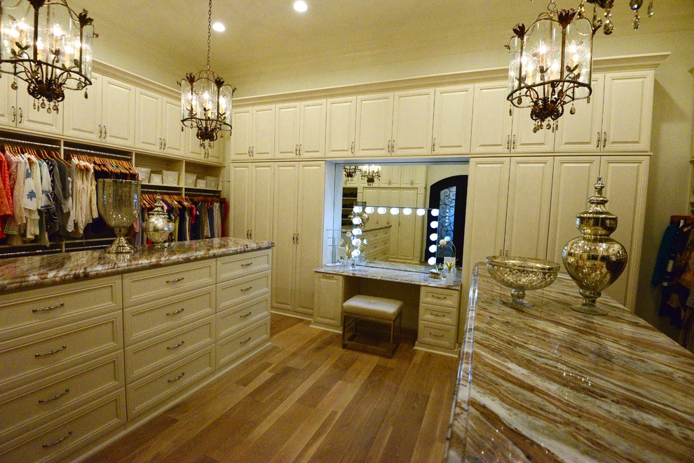 Modelo de armario y vestidor clásico extra grande con suelo de madera clara y suelo beige