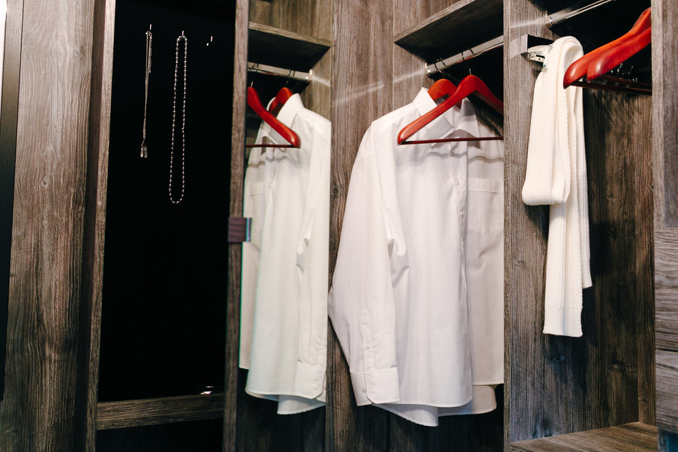 Foto de armario vestidor unisex moderno de tamaño medio con armarios abiertos, puertas de armario de madera oscura y suelo de baldosas de terracota