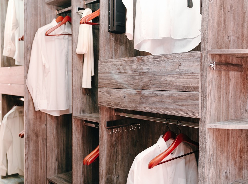 Cette image montre un dressing minimaliste en bois brun de taille moyenne et neutre avec un placard sans porte et tomettes au sol.