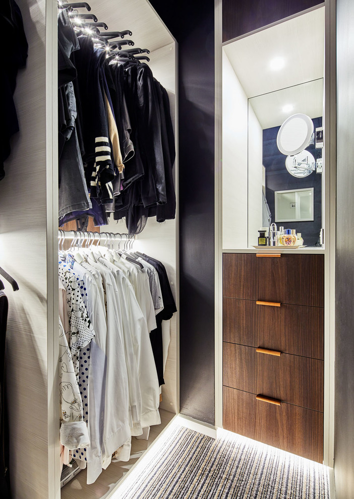 Foto di uno spazio per vestirsi unisex minimal di medie dimensioni con ante lisce, ante in legno scuro, moquette e pavimento beige