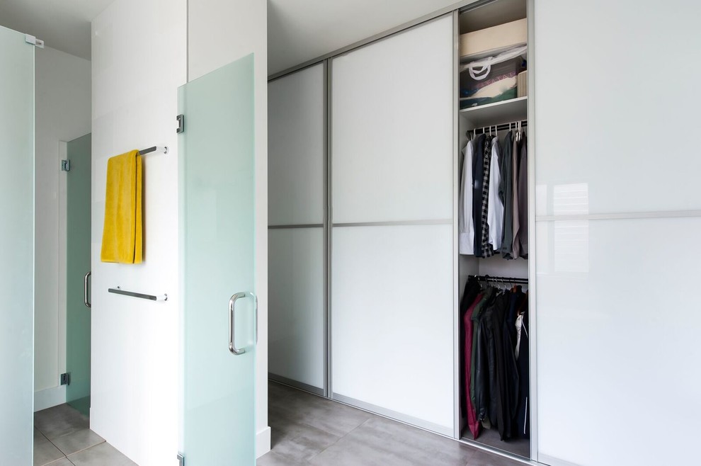 Inspiration för mellanstora moderna walk-in-closets för könsneutrala, med luckor med glaspanel, vita skåp och betonggolv