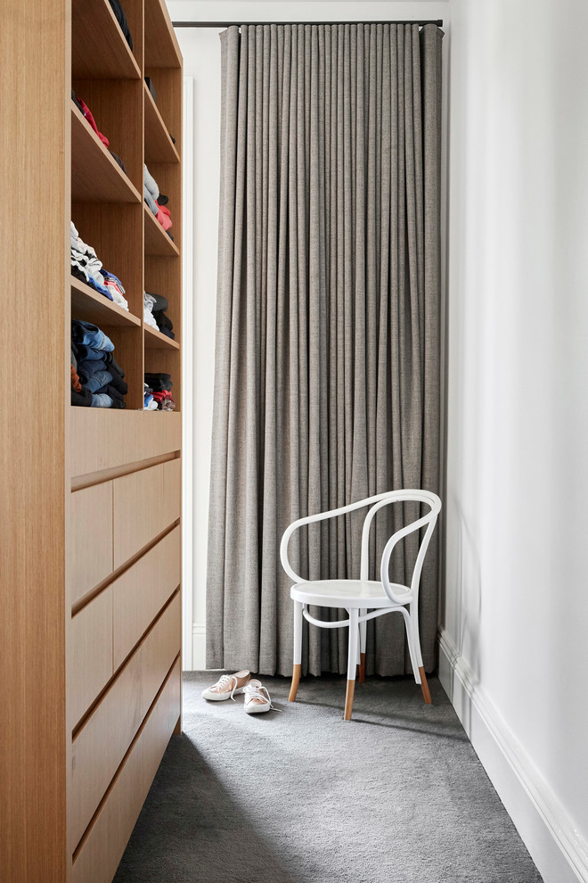 Foto de armario vestidor unisex actual de tamaño medio con armarios con paneles lisos, puertas de armario de madera clara, moqueta y suelo gris