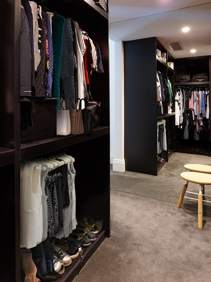 Design ideas for a medium sized contemporary gender neutral walk-in wardrobe in Melbourne with open cabinets, dark wood cabinets, carpet and grey floors.
