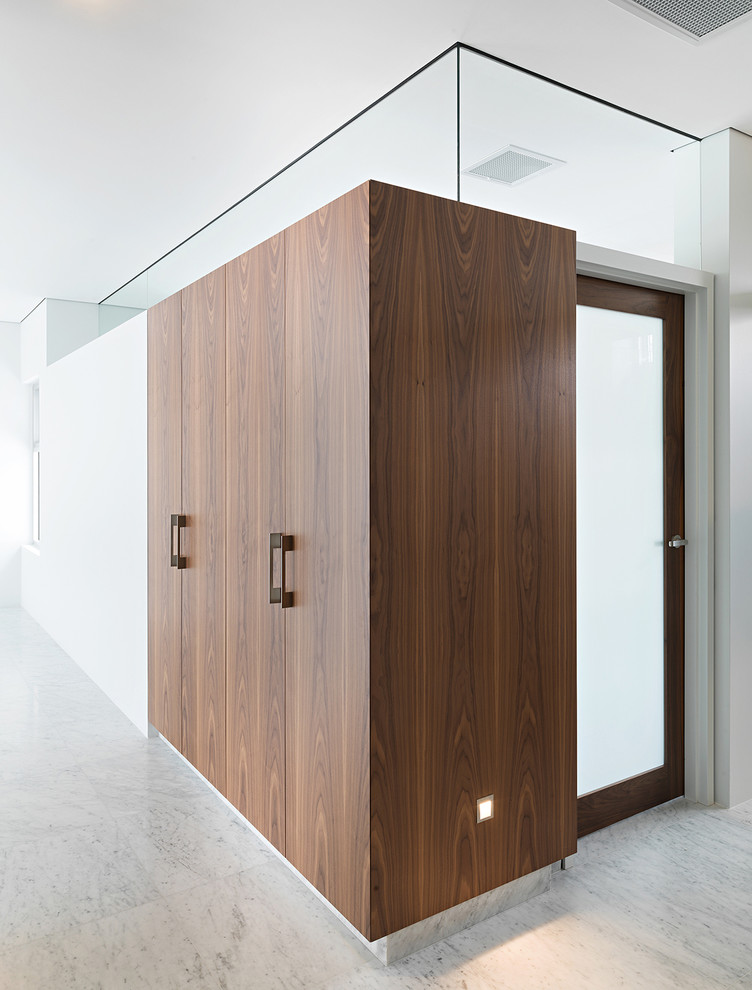 Idee per un piccolo armadio o armadio a muro unisex contemporaneo con ante in legno scuro e pavimento in marmo