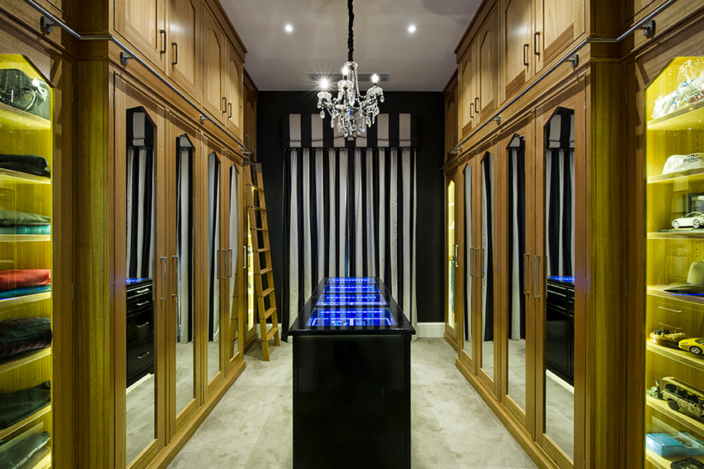 Ejemplo de vestidor unisex actual extra grande con armarios con paneles empotrados, puertas de armario de madera oscura y moqueta