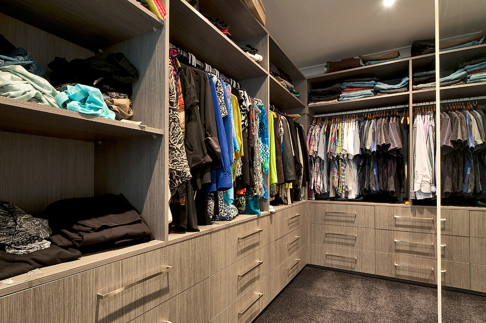 Large modern gender neutral walk-in wardrobe in Gold Coast - Tweed with flat-panel cabinets, light wood cabinets and carpet.