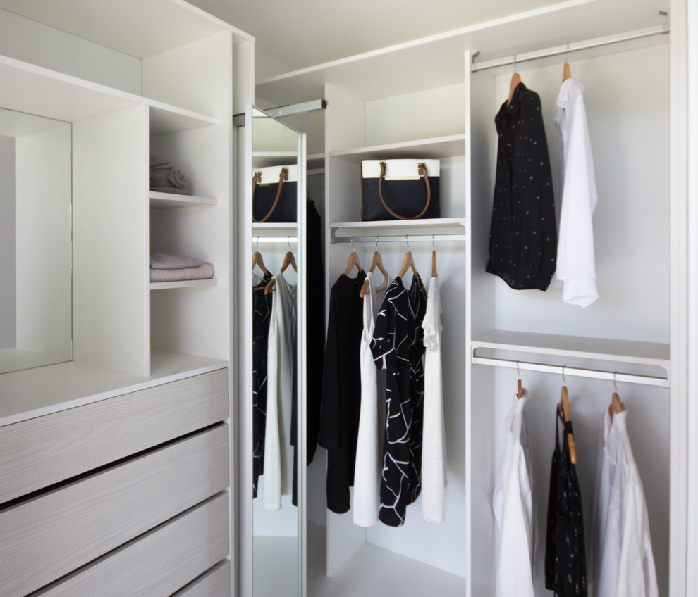 Mid-sized minimalist gender-neutral reach-in closet photo in Wellington with white cabinets
