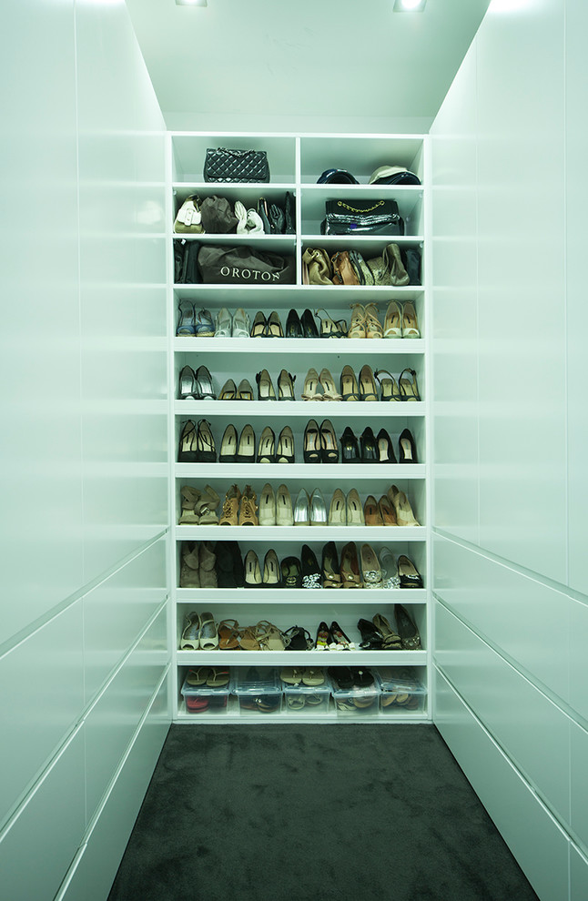 Bild på ett mellanstort funkis walk-in-closet för könsneutrala, med släta luckor, vita skåp och heltäckningsmatta