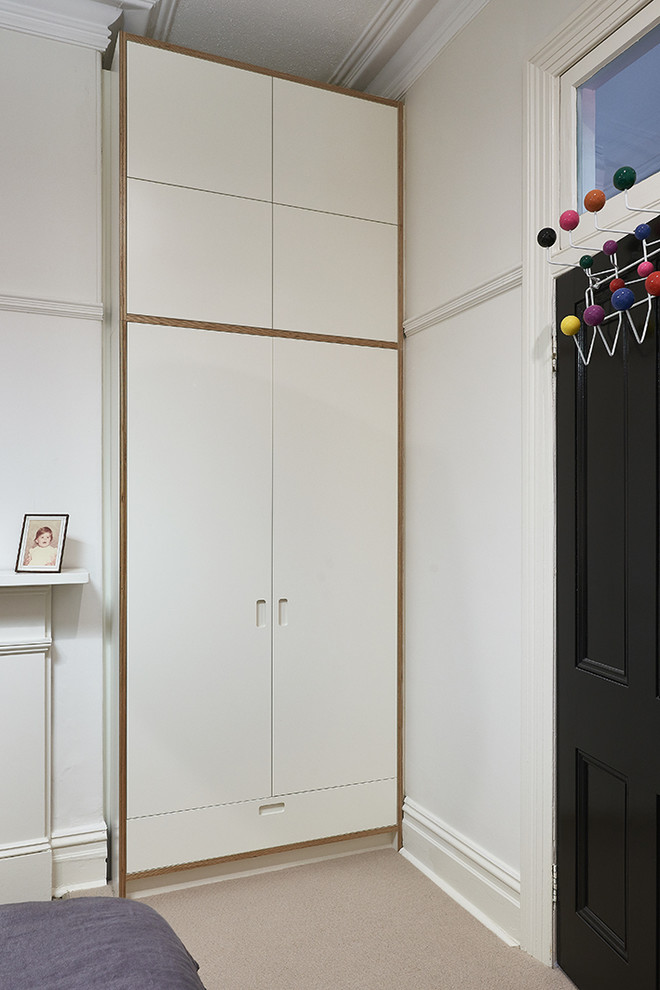 Ispirazione per un armadio o armadio a muro unisex design di medie dimensioni con ante bianche e moquette