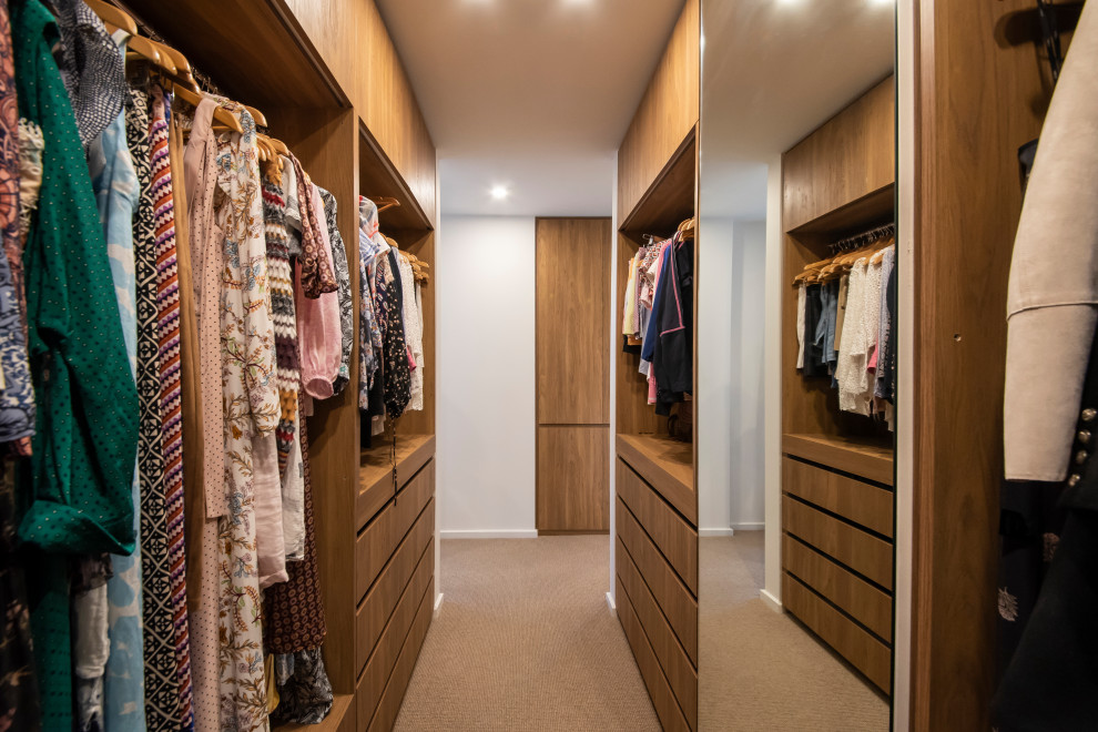 Foto de armario vestidor unisex marinero extra grande con armarios con paneles lisos, puertas de armario de madera oscura, moqueta y suelo beige