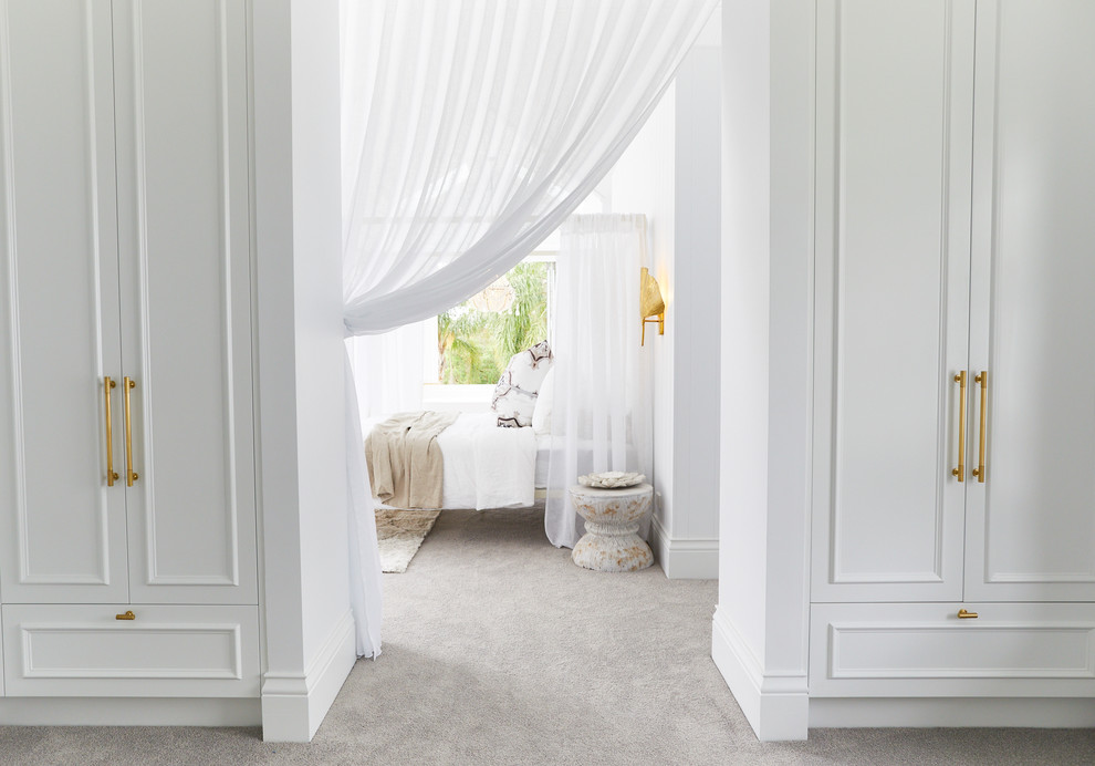 Пример оригинального дизайна: большая гардеробная комната унисекс в морском стиле с фасадами с декоративным кантом, белыми фасадами, ковровым покрытием и серым полом