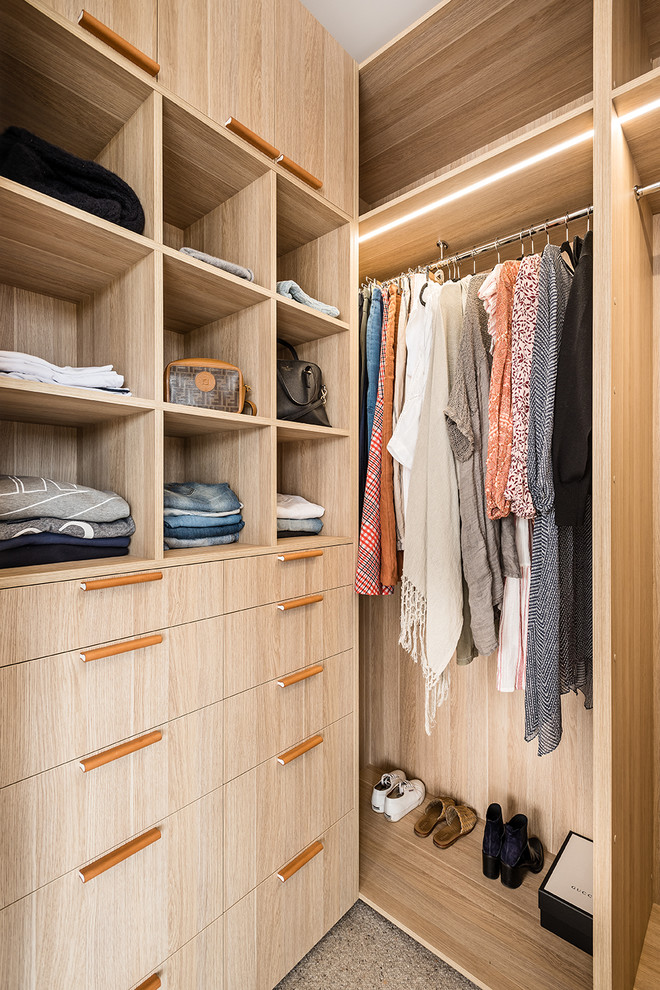 Small trendy gender-neutral carpeted and beige floor walk-in closet photo in Melbourne with flat-panel cabinets and medium tone wood cabinets