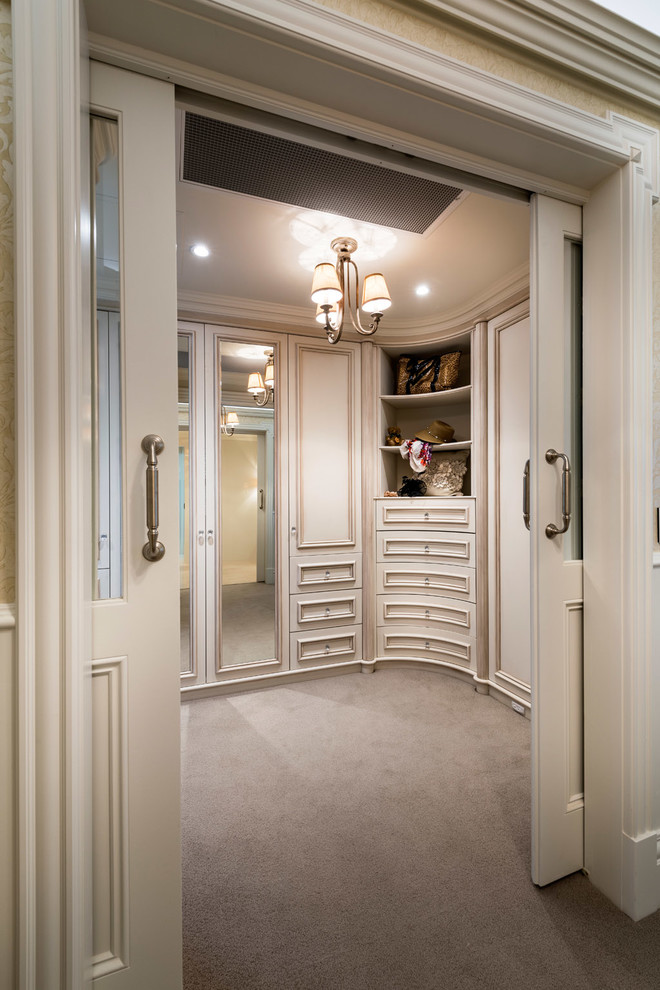 Photo of a large traditional gender neutral walk-in wardrobe in Perth with recessed-panel cabinets, distressed cabinets and carpet.