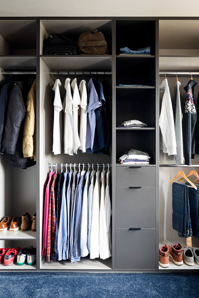 Diseño de armario vestidor de hombre contemporáneo grande con armarios abiertos, puertas de armario grises, moqueta y suelo azul