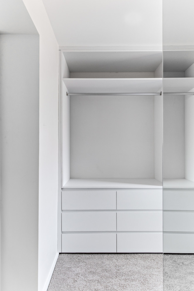 Foto di una cabina armadio unisex design di medie dimensioni con moquette e pavimento beige