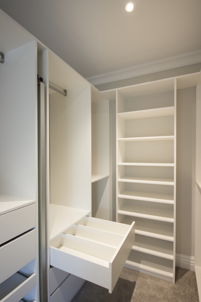 На фото: гардеробная комната среднего размера, унисекс в стиле модернизм с белыми фасадами