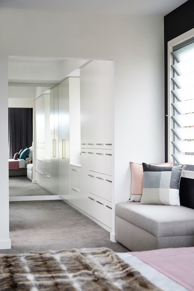 Walk-in closet - mid-sized contemporary gender-neutral carpeted walk-in closet idea in Sydney with flat-panel cabinets and white cabinets