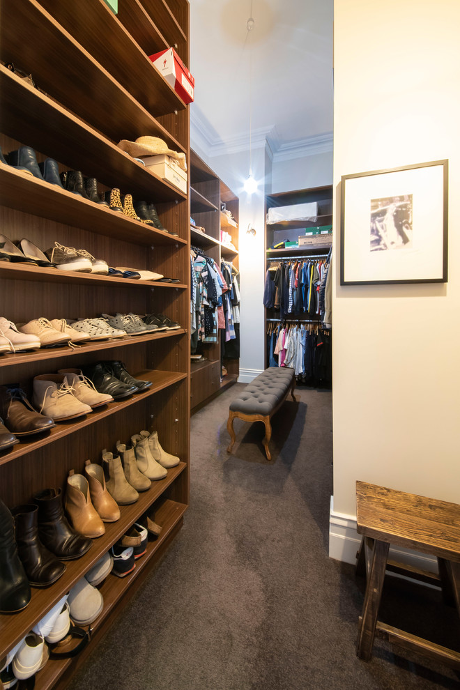 Expansive traditional gender neutral walk-in wardrobe in Melbourne with open cabinets, medium wood cabinets, carpet and grey floors.