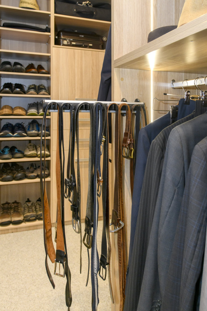 Modelo de armario vestidor unisex moderno extra grande con armarios con paneles lisos, puertas de armario de madera clara, moqueta y suelo gris