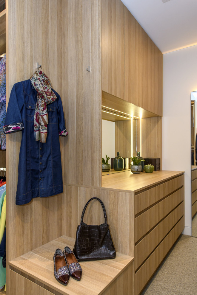 Ejemplo de armario vestidor unisex minimalista extra grande con armarios con paneles lisos, puertas de armario de madera clara, moqueta y suelo gris
