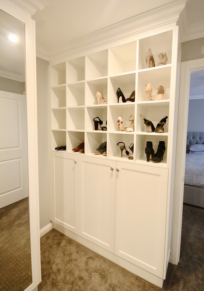 Exempel på ett stort klassiskt walk-in-closet för kvinnor, med luckor med infälld panel, vita skåp, mellanmörkt trägolv och brunt golv
