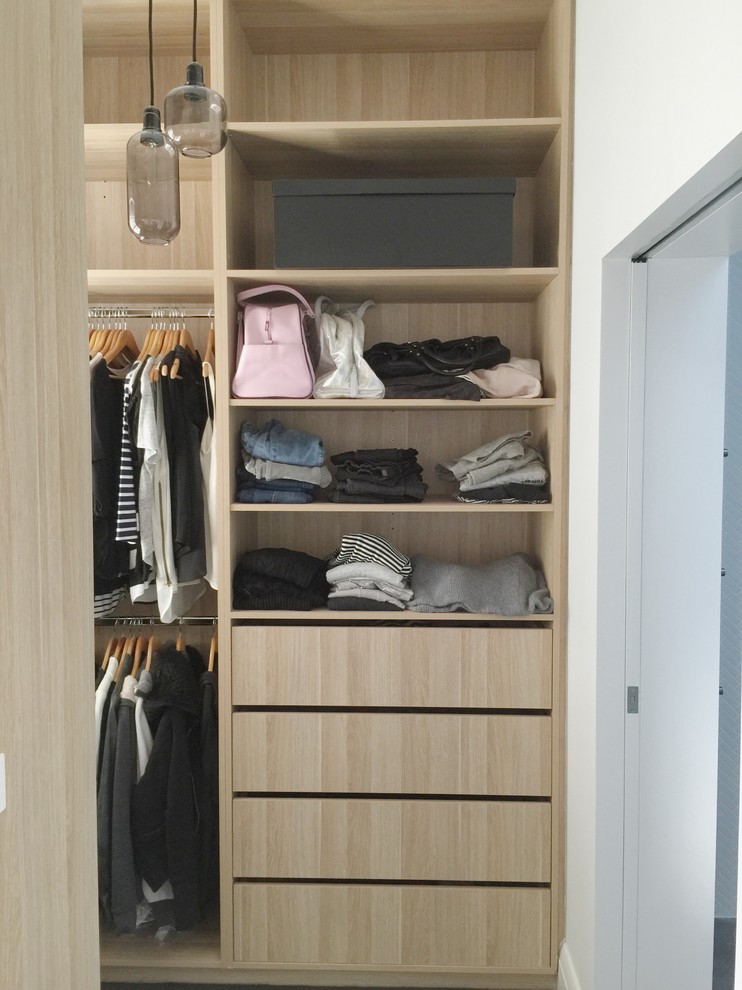 Diseño de armario vestidor de mujer moderno pequeño con armarios abiertos, puertas de armario de madera clara y moqueta