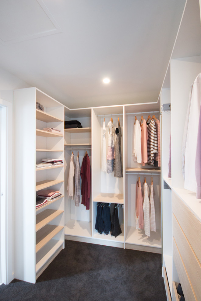 This is an example of a medium sized scandi gender neutral walk-in wardrobe in Wellington with white cabinets.