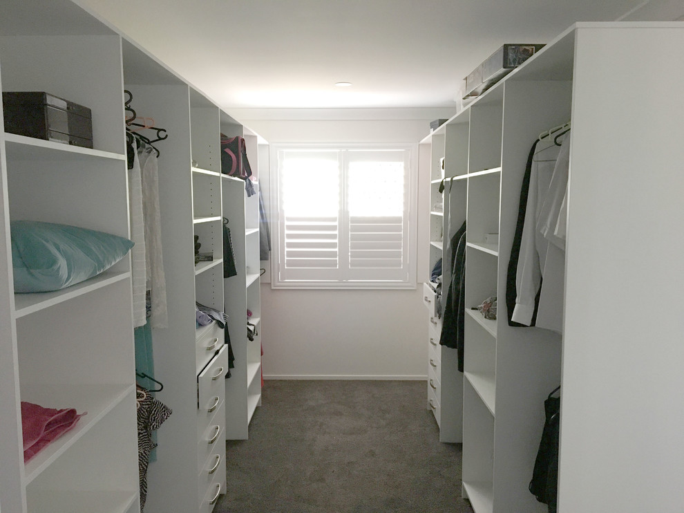 На фото: гардеробная комната среднего размера, унисекс в современном стиле с открытыми фасадами, белыми фасадами, ковровым покрытием и серым полом