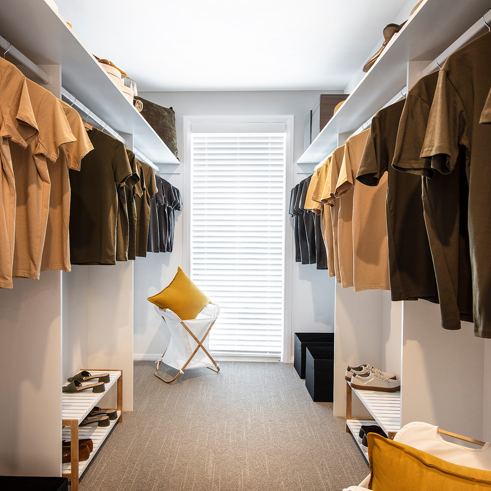 Diseño de vestidor unisex retro de tamaño medio con armarios abiertos, puertas de armario blancas, moqueta y suelo beige