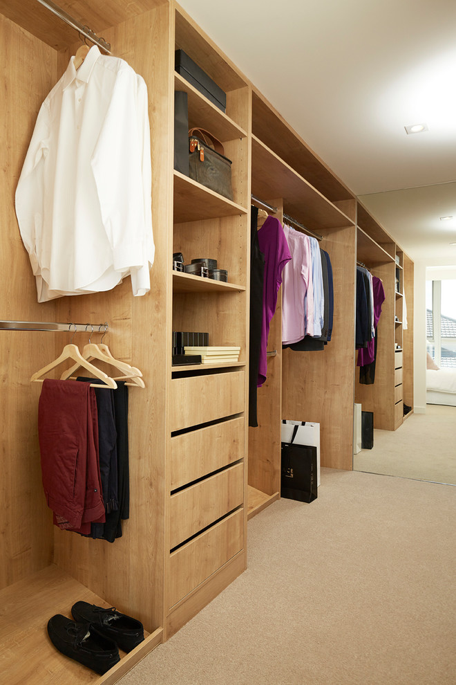 Inspiration for a contemporary gender neutral walk-in wardrobe in Perth with flat-panel cabinets, light wood cabinets, carpet, beige floors and feature lighting.