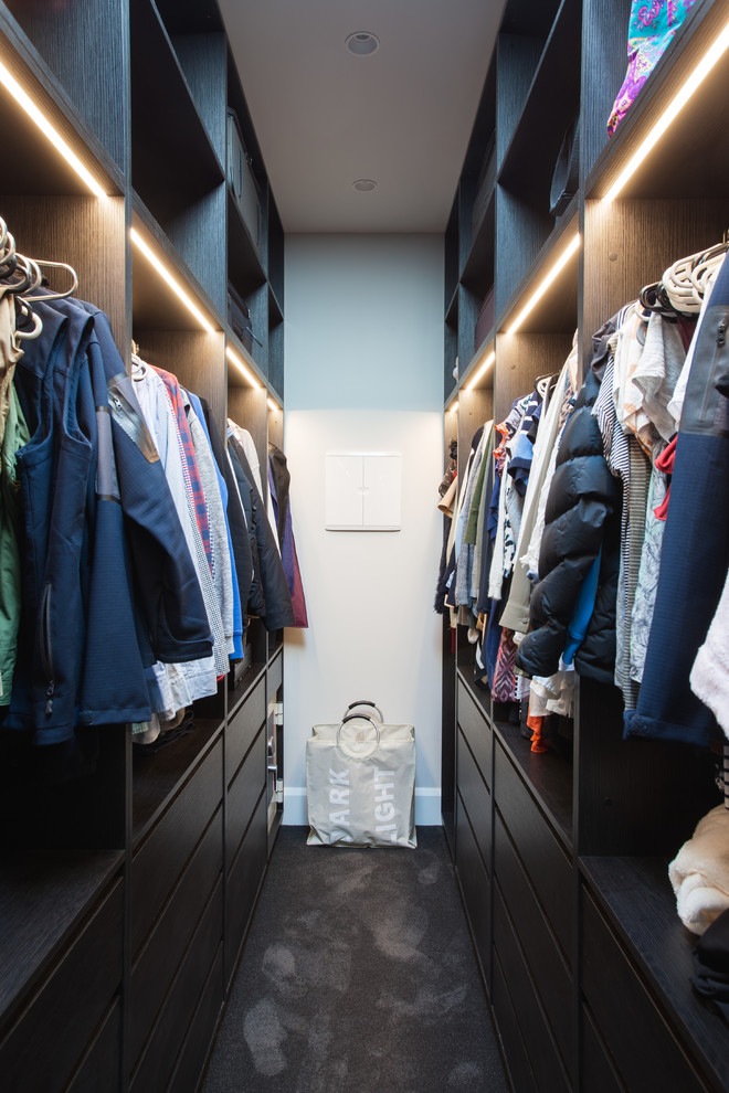 Foto de armario vestidor unisex moderno de tamaño medio con armarios abiertos, puertas de armario de madera en tonos medios, moqueta y suelo negro