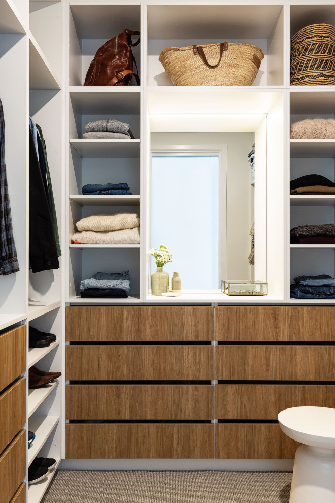 Exemple d'un grand dressing bord de mer en bois brun neutre avec un placard sans porte, moquette et un sol gris.