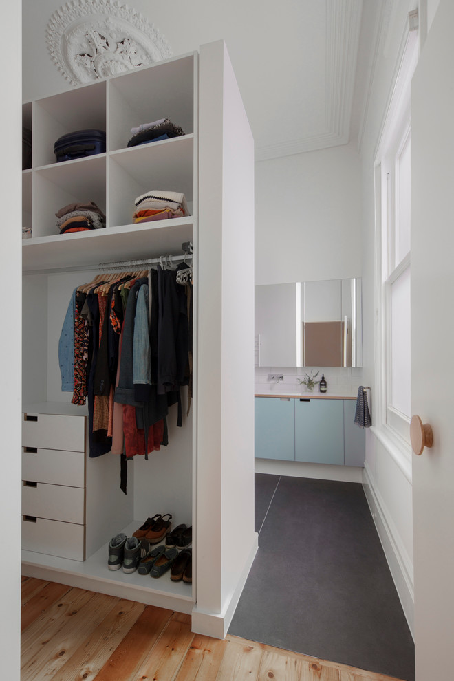 Foto de armario vestidor unisex actual de tamaño medio con armarios abiertos, puertas de armario blancas y suelo de madera clara