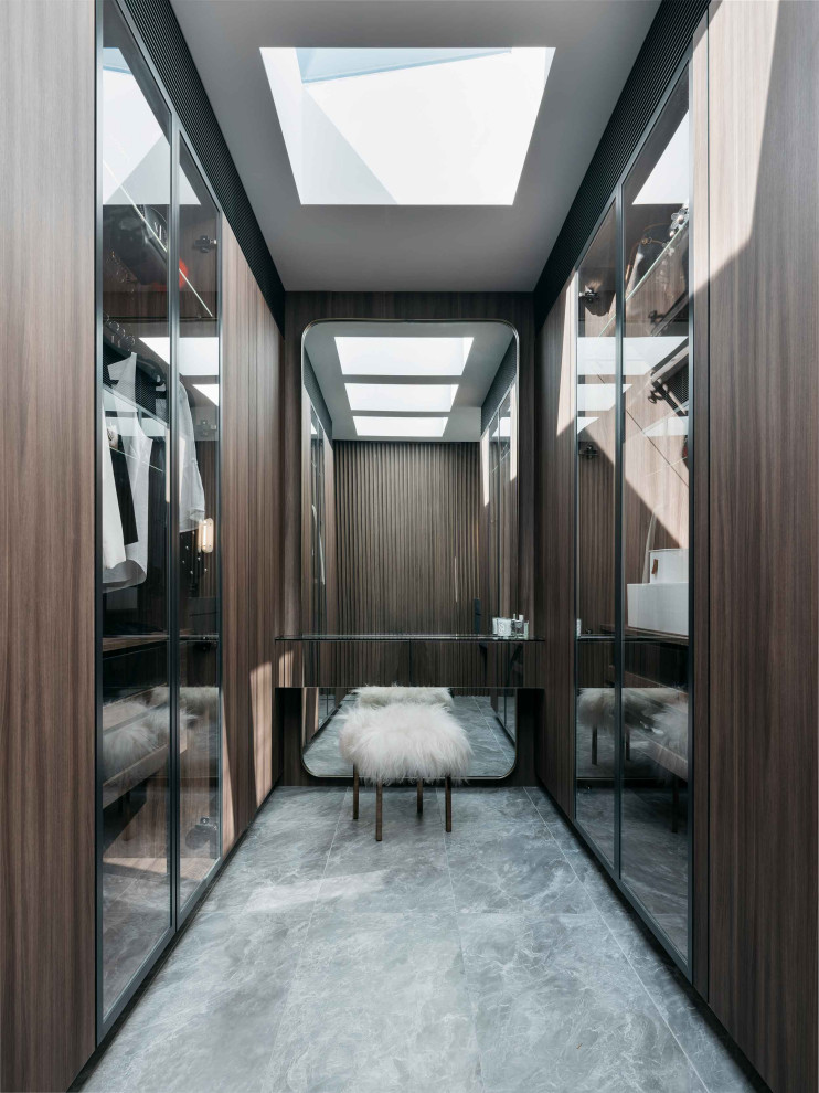 На фото: гардеробная комната в современном стиле с полом из керамогранита, серым полом, стеклянными фасадами и темными деревянными фасадами с