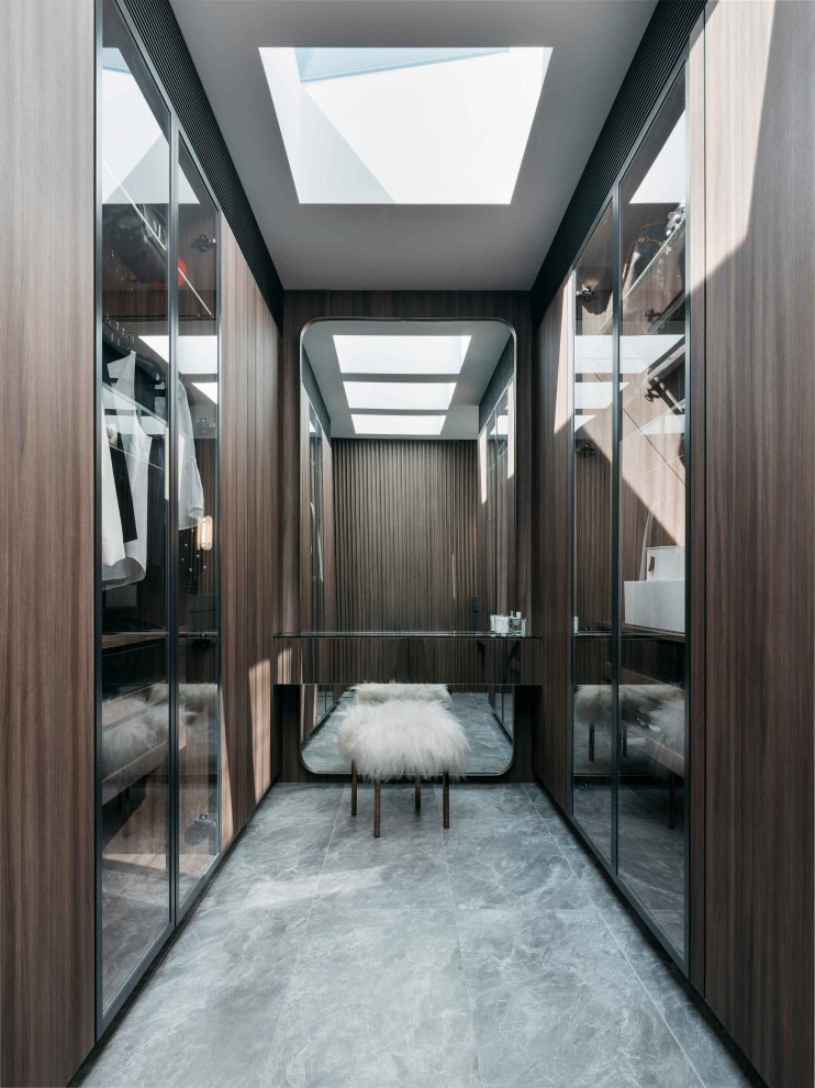 Example of a trendy porcelain tile and gray floor walk-in closet design in Sydney with glass-front cabinets and dark wood cabinets