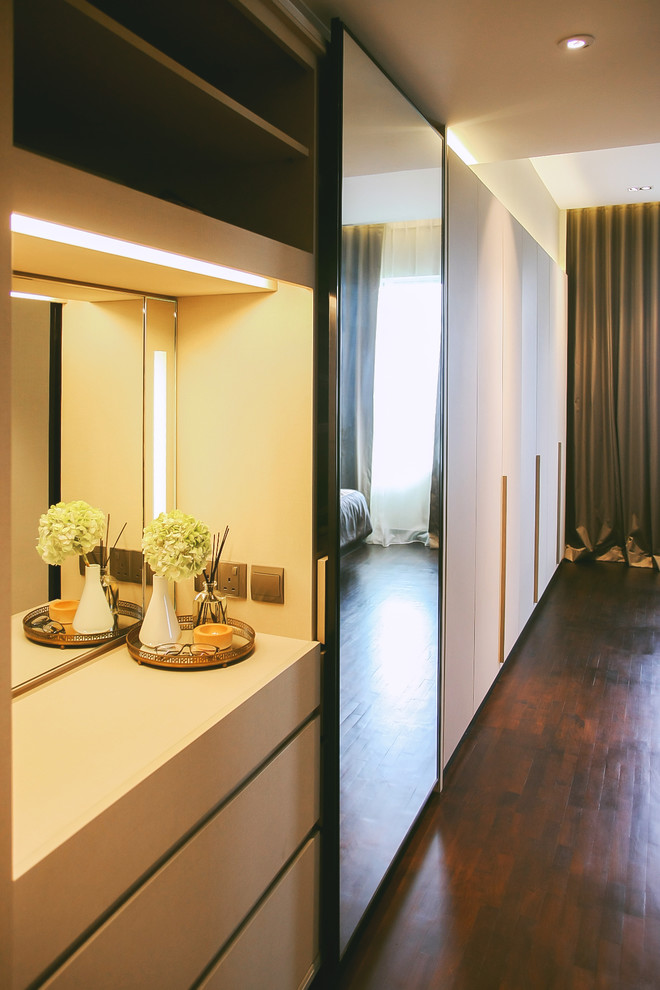 Cette image montre un petit dressing room design neutre avec des portes de placard beiges et un placard à porte plane.