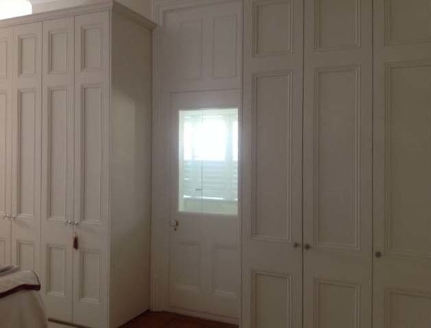 Cette photo montre un grand dressing room victorien neutre avec un placard avec porte à panneau encastré.